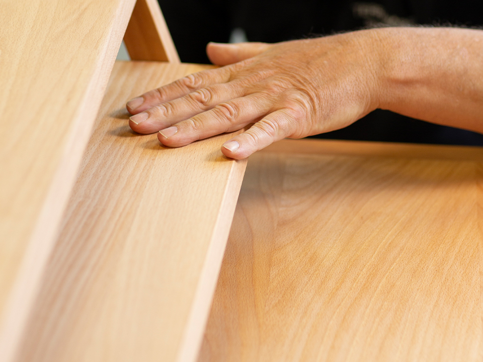 Hände auf Massivholzregal
