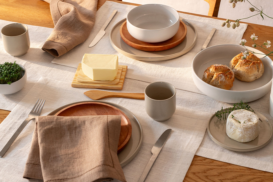 Frühstückstisch mit Gläser, Schüsseln und Tellern.