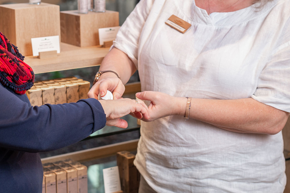 Ein Pflegeprodukt wird von einer Beraterin aufgetragen