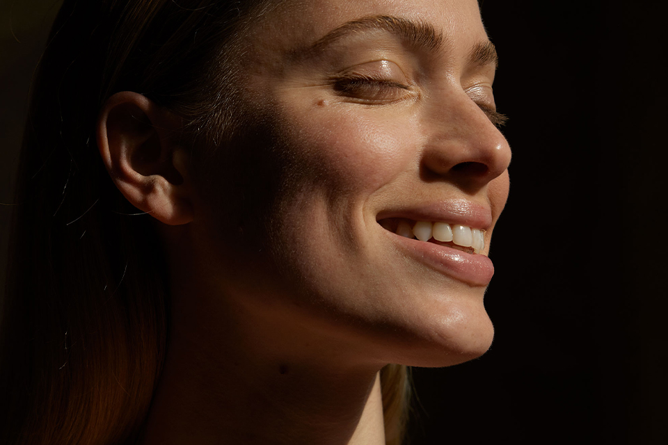 Frau lächelnd im Sonnenlicht