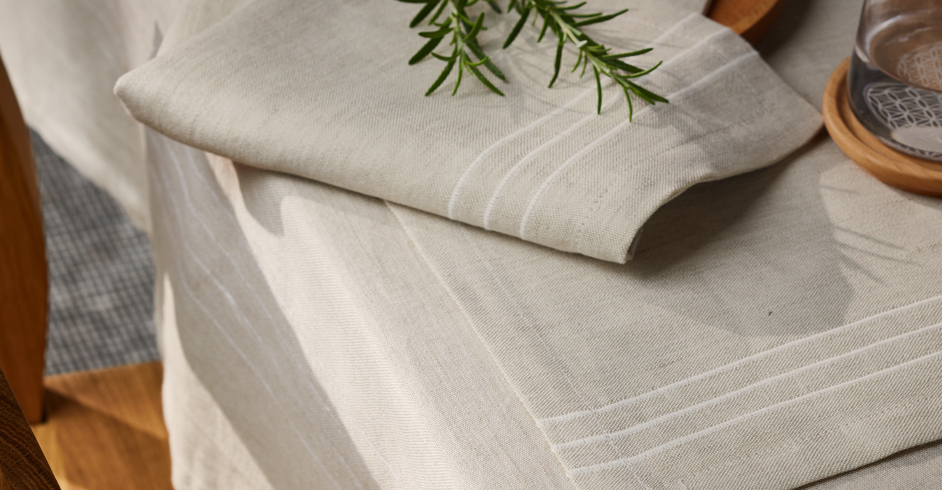 Graue Tischdecken auf Tisch liegend  mit Rosmarinzweig