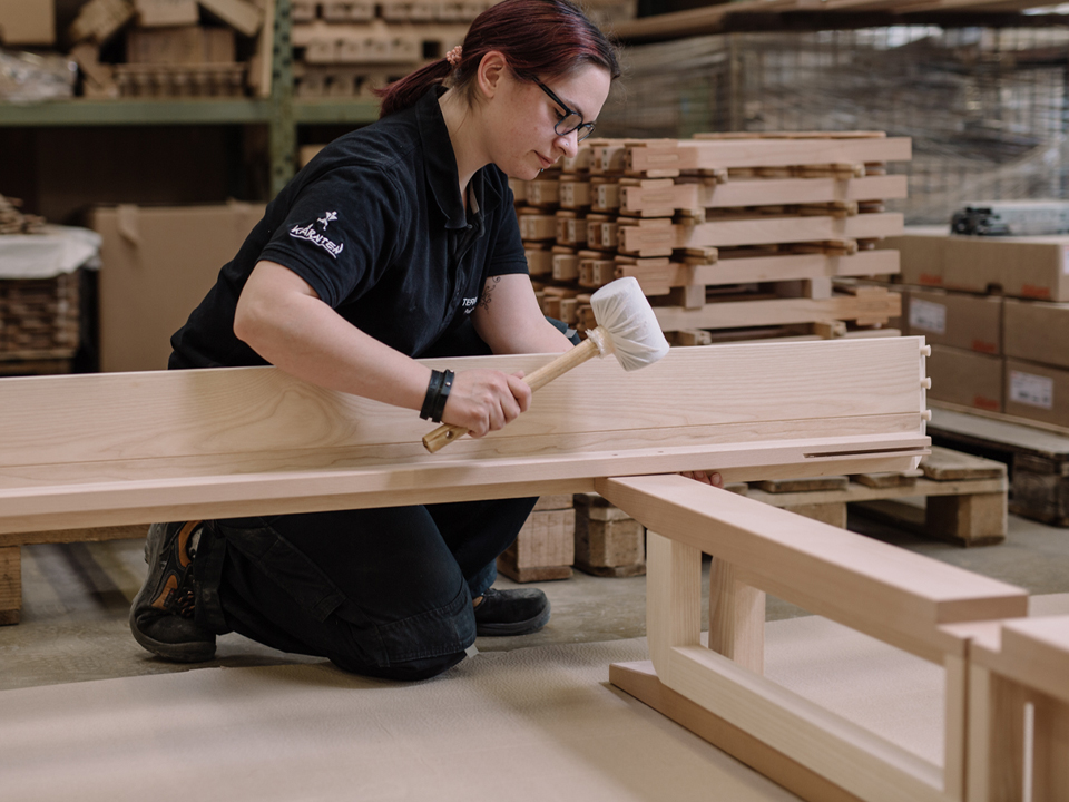 Frau beim fertigen eines Bettes