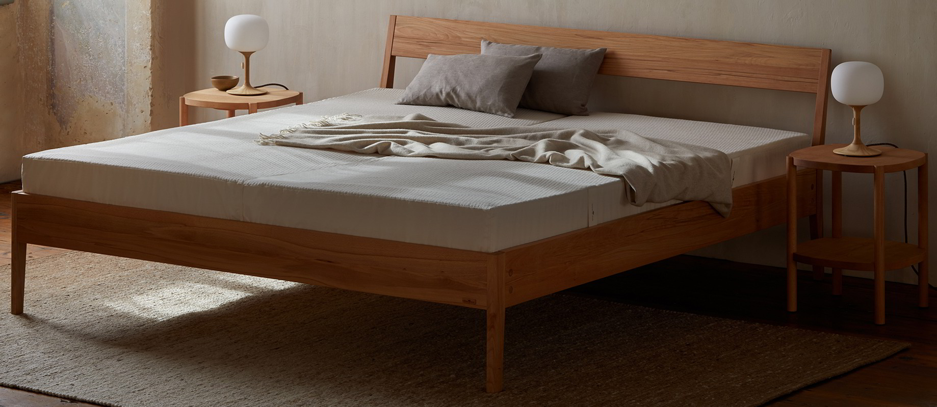 Ein Holzbett mit einer niedrigen Matratze