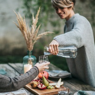 Frau mit Krug schenkt Wasser ein 