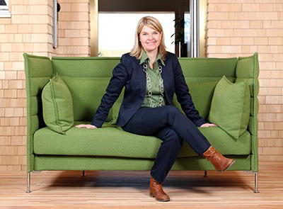 Geschäftsführerin Dagmar Fritz-Kramer von Baufritz auf grünem Sofa sitzend