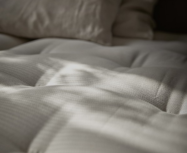 Zwei Matratzen liegen in einem Holzbett