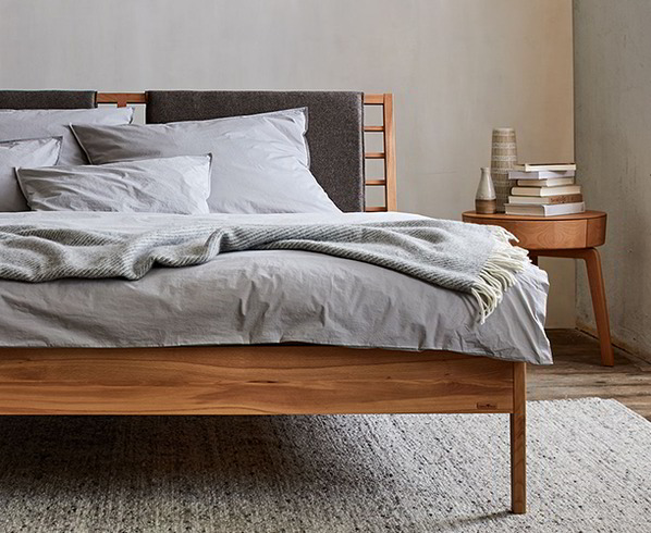 Polsterbett in grau steht im Schlafzimmer