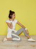 Studioaufnahme: Model vor gelbem Hintergrund mit weißem Carmen-Shirt, graue Jogginghose und Pullover A-Linie