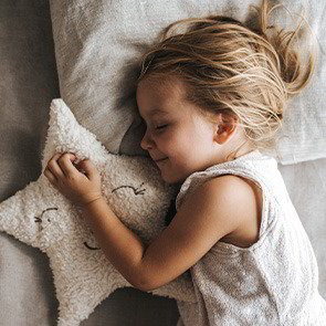 schlafendes Kind mit Kuschelkissen Stern