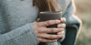 Frau mit Kaffeebecher in der Hand
