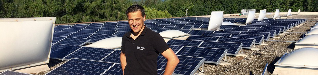 Betriebsleiter Martin Reiber und die Solaranlage auf dem Dach der Grüne Erde Tischlerei