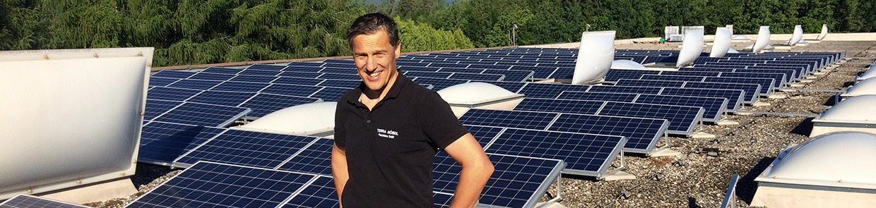 Betriebsleiter Martin Reiber und die Solaranlage auf dem Dach der Grüne Erde Tischlerei