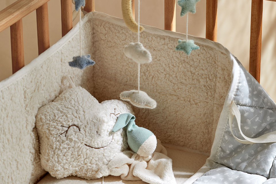 Babybett mit Kissen und Mobile