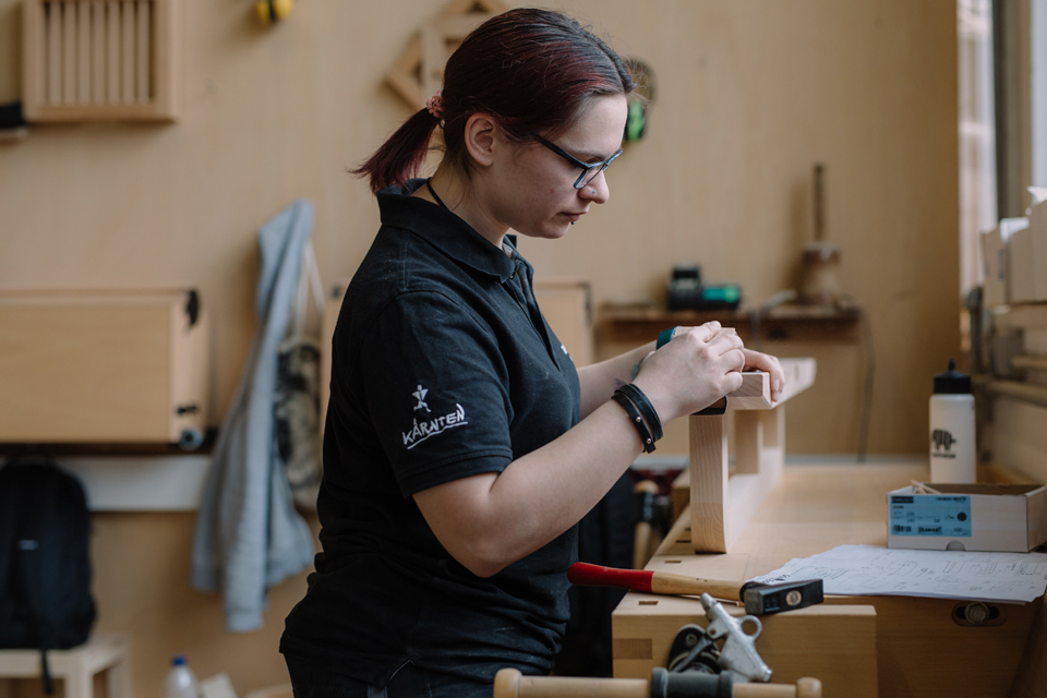 Mitarbeiterin die ein Fußgestell des Bettes Almara schleift