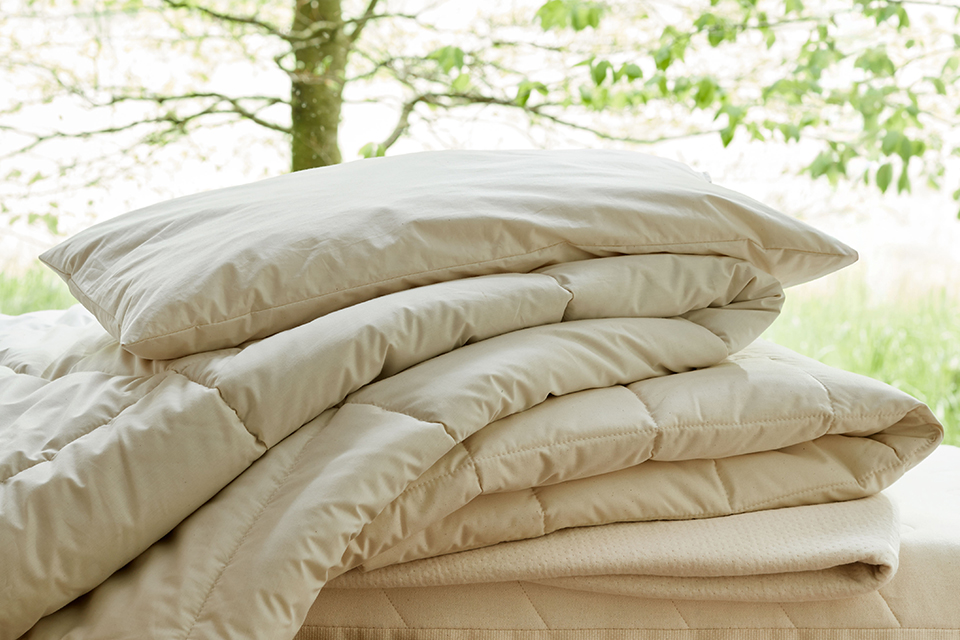 Ökologische Bettwaren vor einer Wiese mit Bäumen