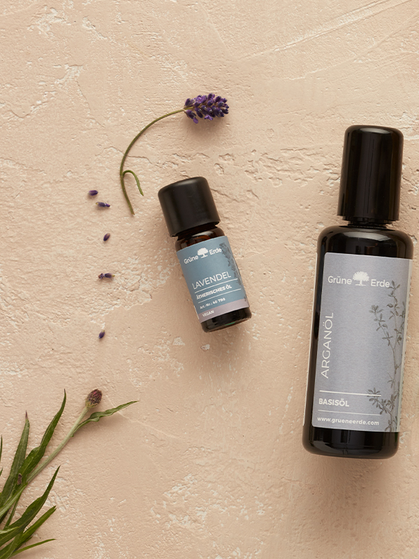 Basisöl und Aromaöl mit dekorativen Pflanzen auf hellem Untergrund