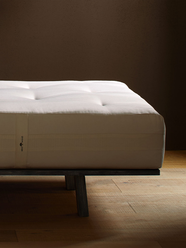 Naturmatratze auf einem dunklen Holzgestell