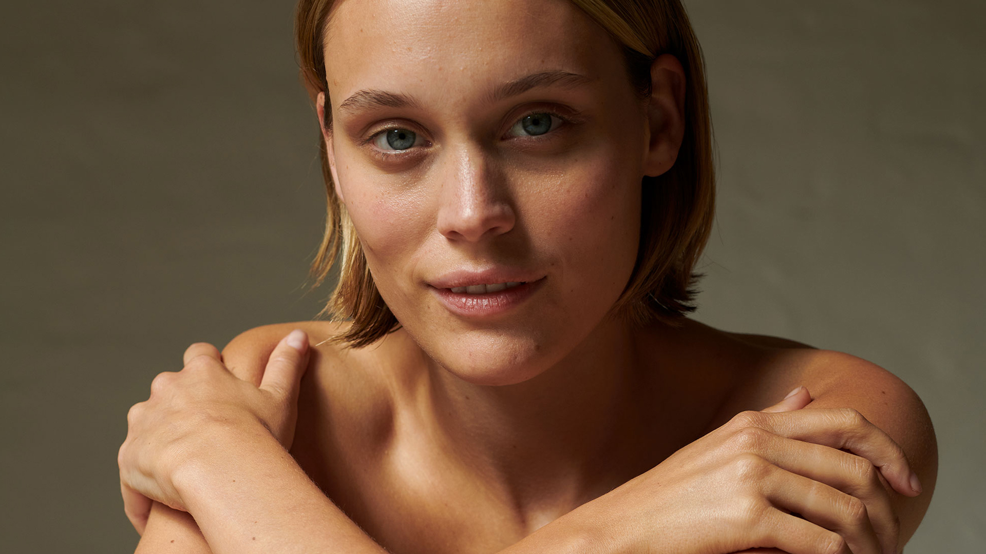 Frau sitzt mit verschränkten Armen