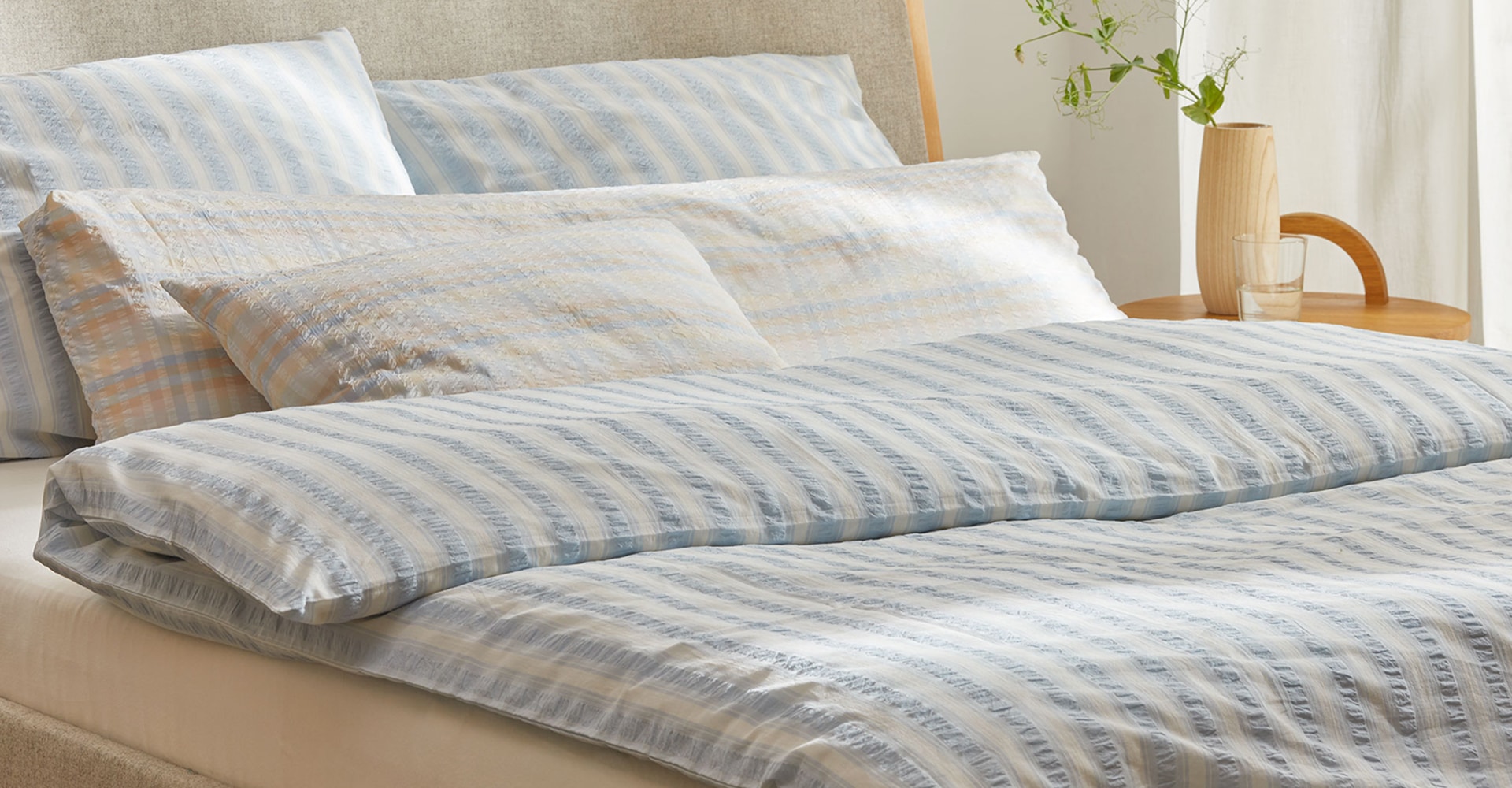Gestreifte Bettwäsche im grauen Bett