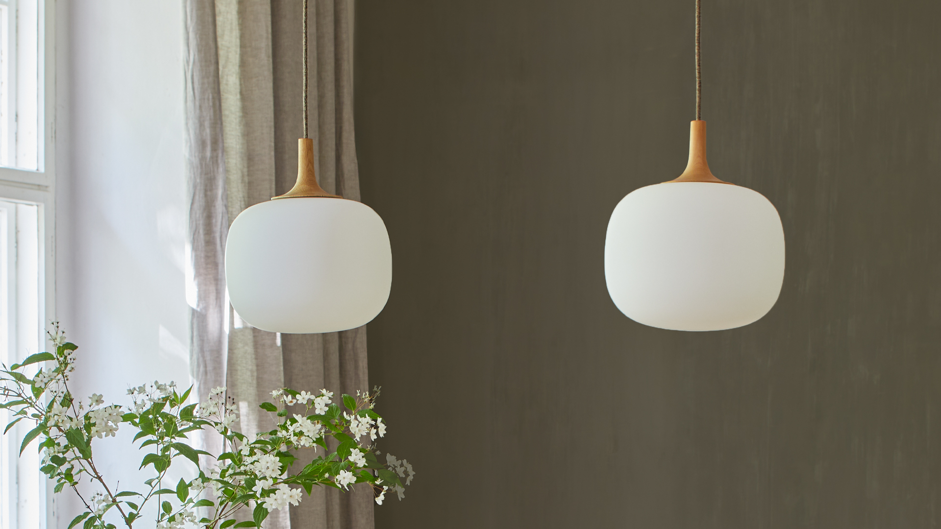 Moderne Hängeleuchten neben Fenster mit Pflanzen