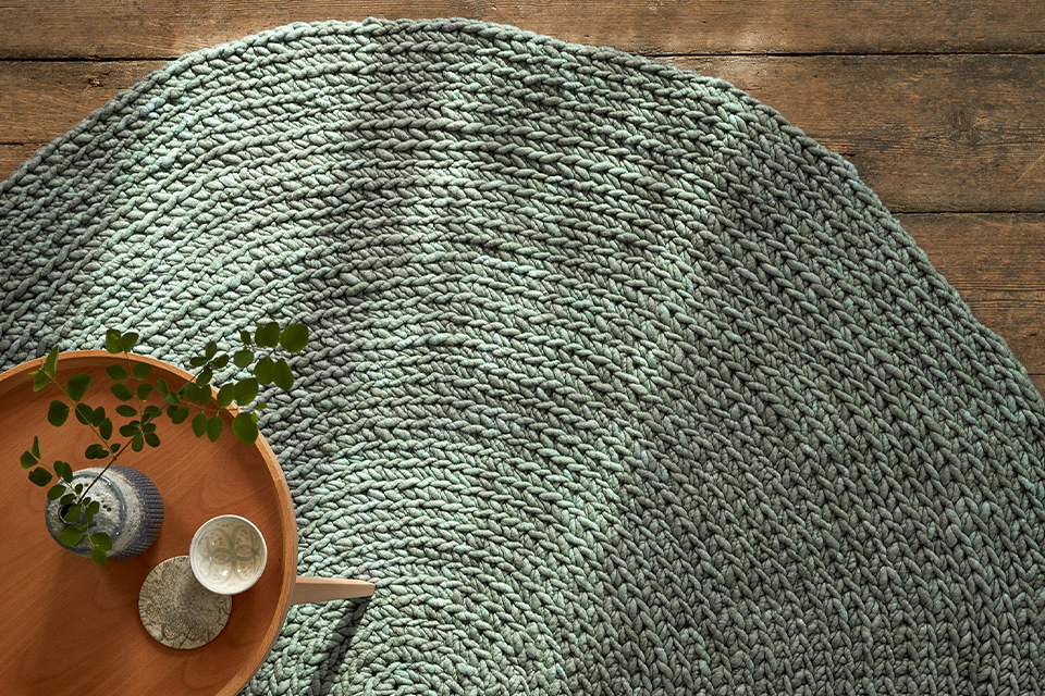 Grüner Teppich mit einem kleinen Holztisch auf dem Boden liegend