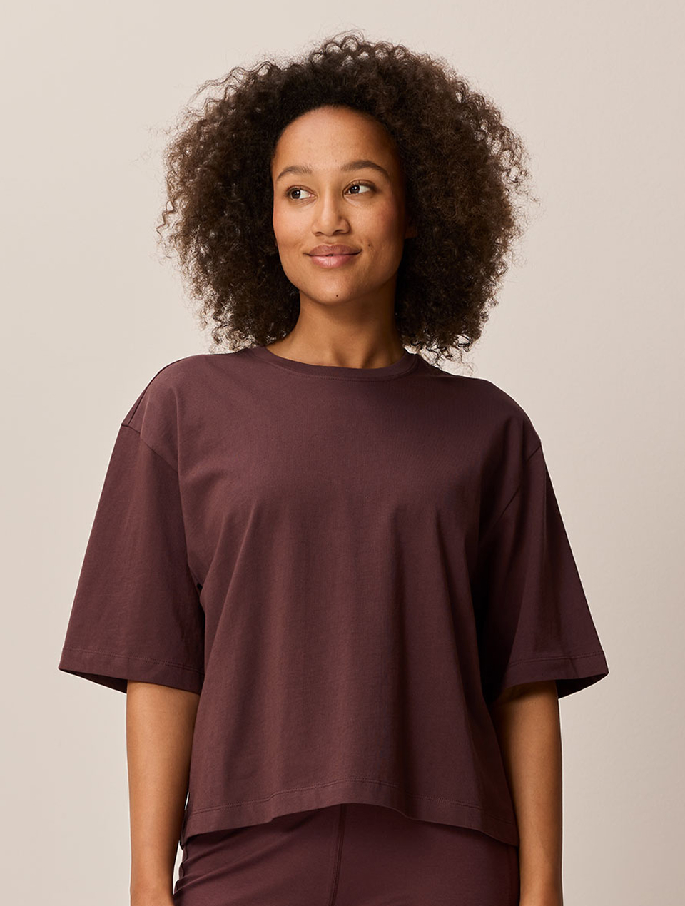 Lächelnde Frau trägt ein dunkelrotes T-Shirt