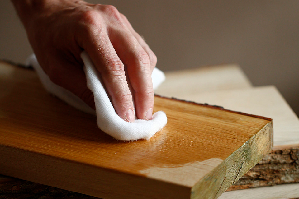 Hand beim einölen eines Holzbretts