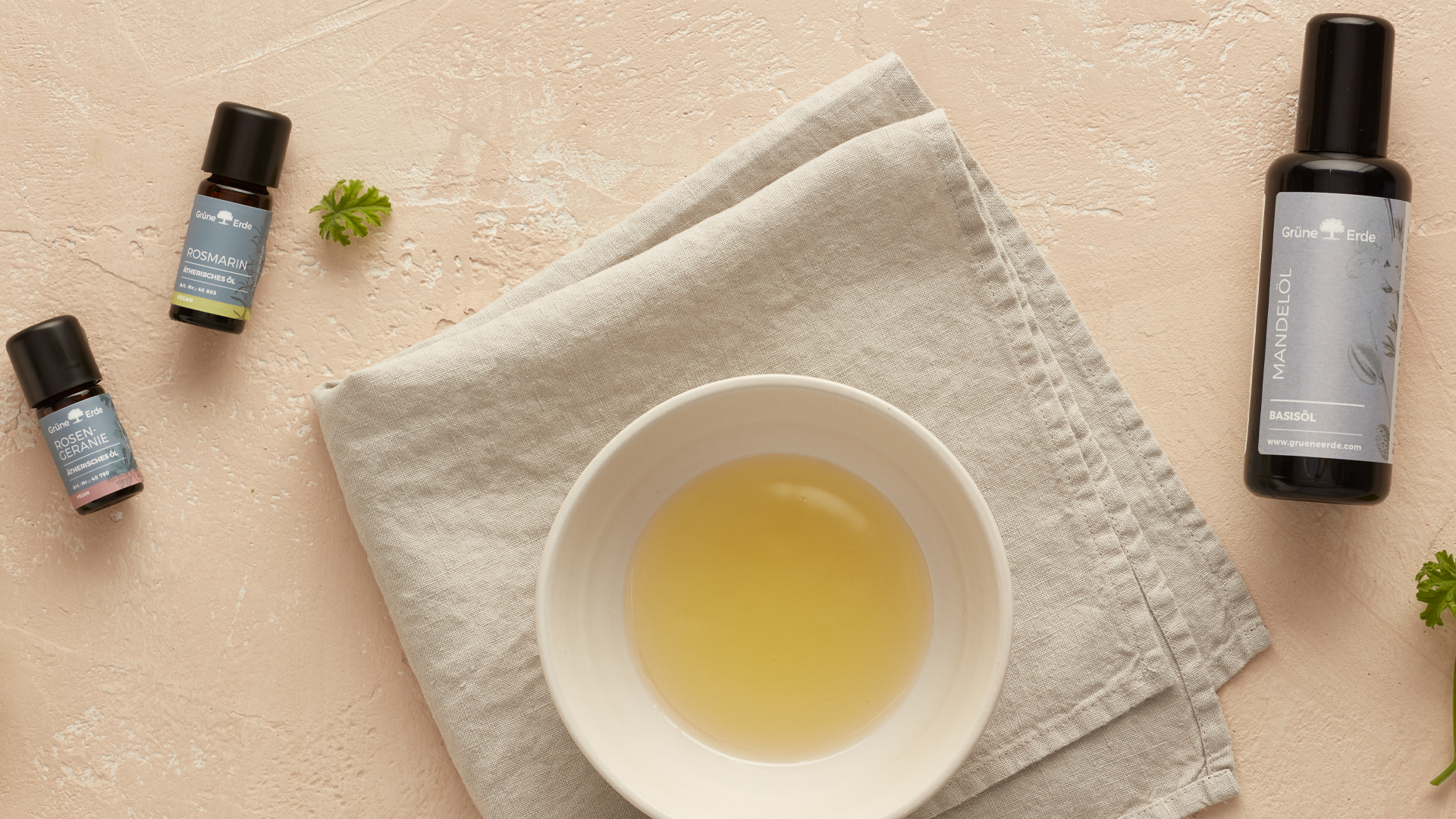 Basisöl und ätherische Öle neben einer Schale mit Öl