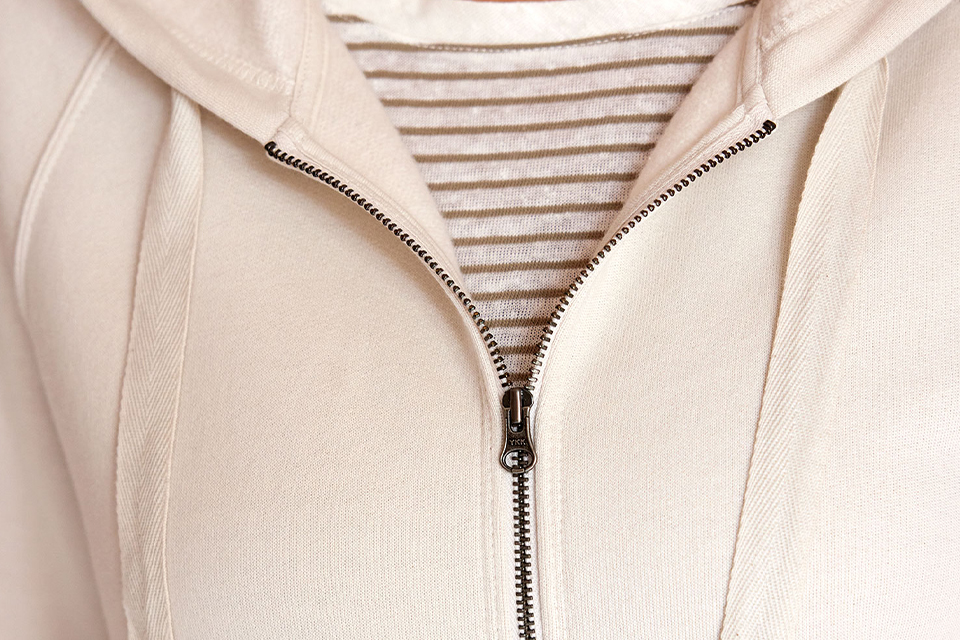 Detailaufnahme einer hellen Jacke mit Reisverschluss