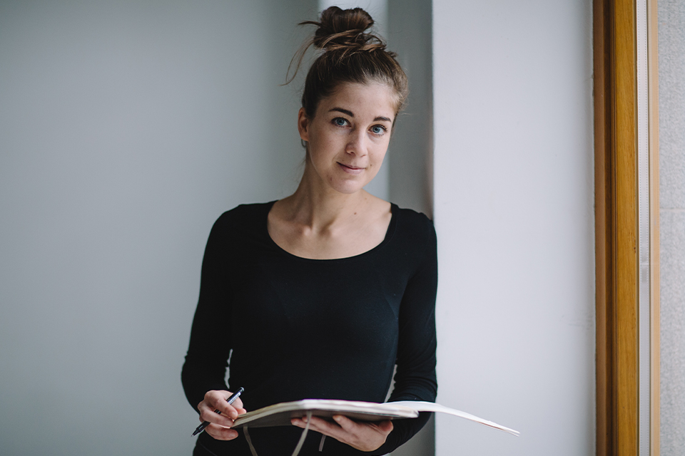 Lächelnde Frau hält Buch in den Händen