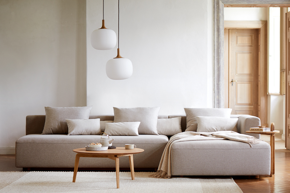 Helles Wohnzimmer mit Sofa und moderner Hängeleuchte