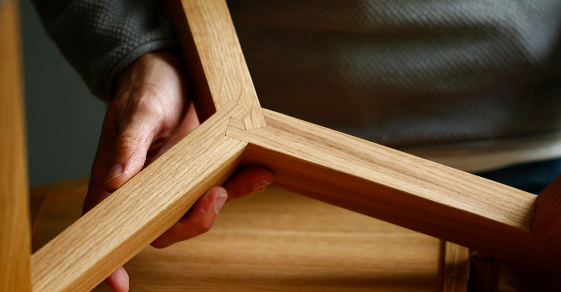 Hand hält Tischbeine aus Holz