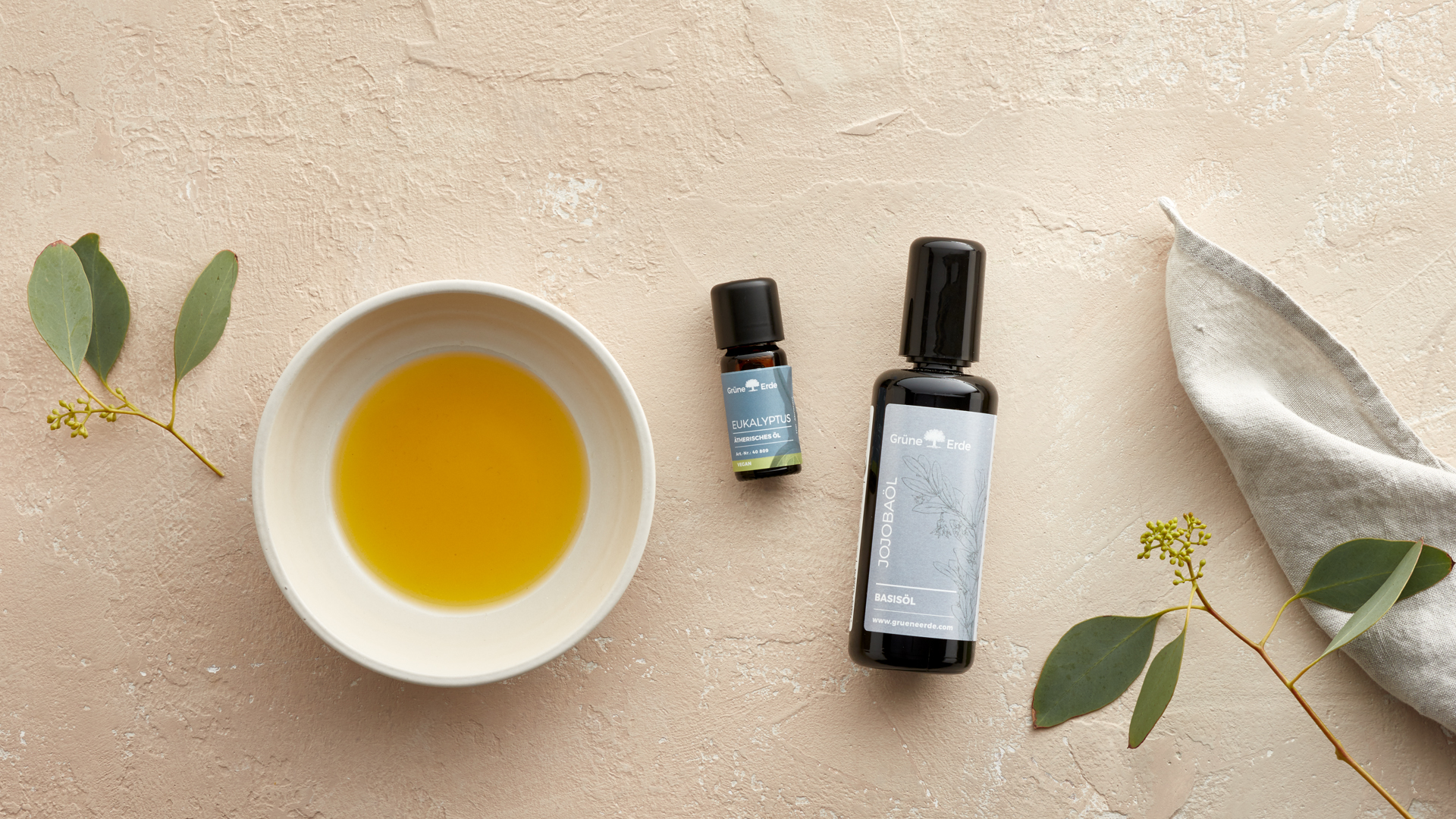 Basisöl und Aromaöl neben einer Schüssel mit Öl gefüllt