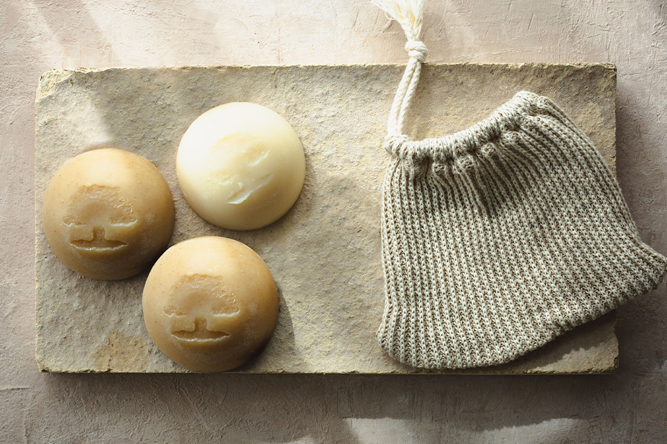 Drei feste Seifen neben einem kleinen Stoffsackerl