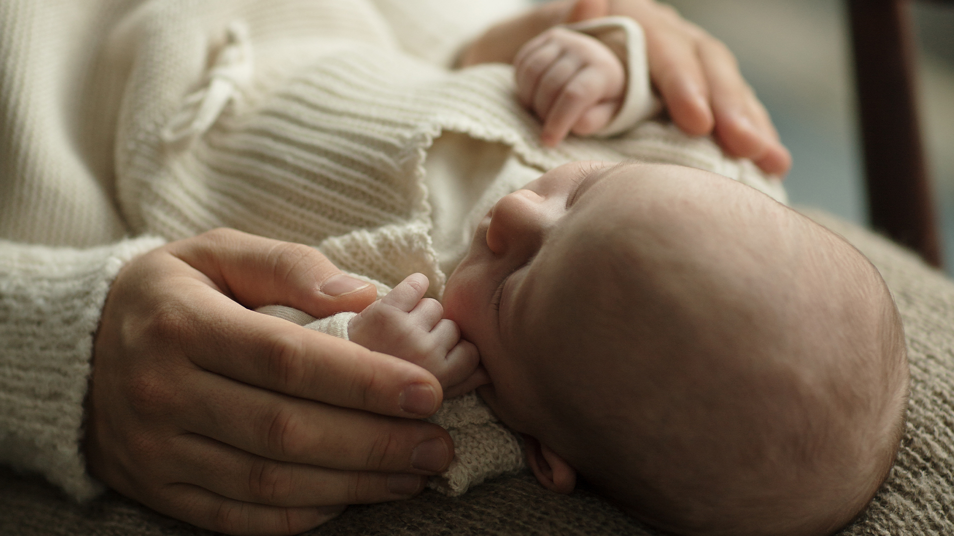 Ein Schlafendes Baby wir im Arm gehalten