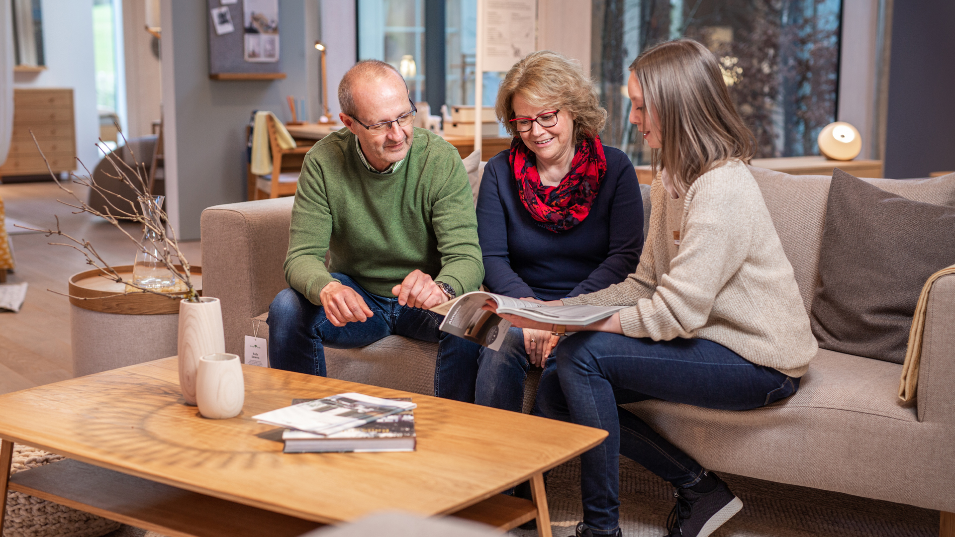Beraterin im Store sieht sich mit Kunden einen Grüne Erde Katalog Katalog an