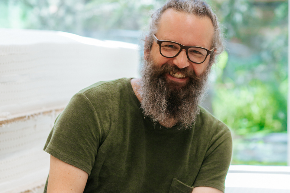 Glücklicher Mann sitz vor einem Fenster
