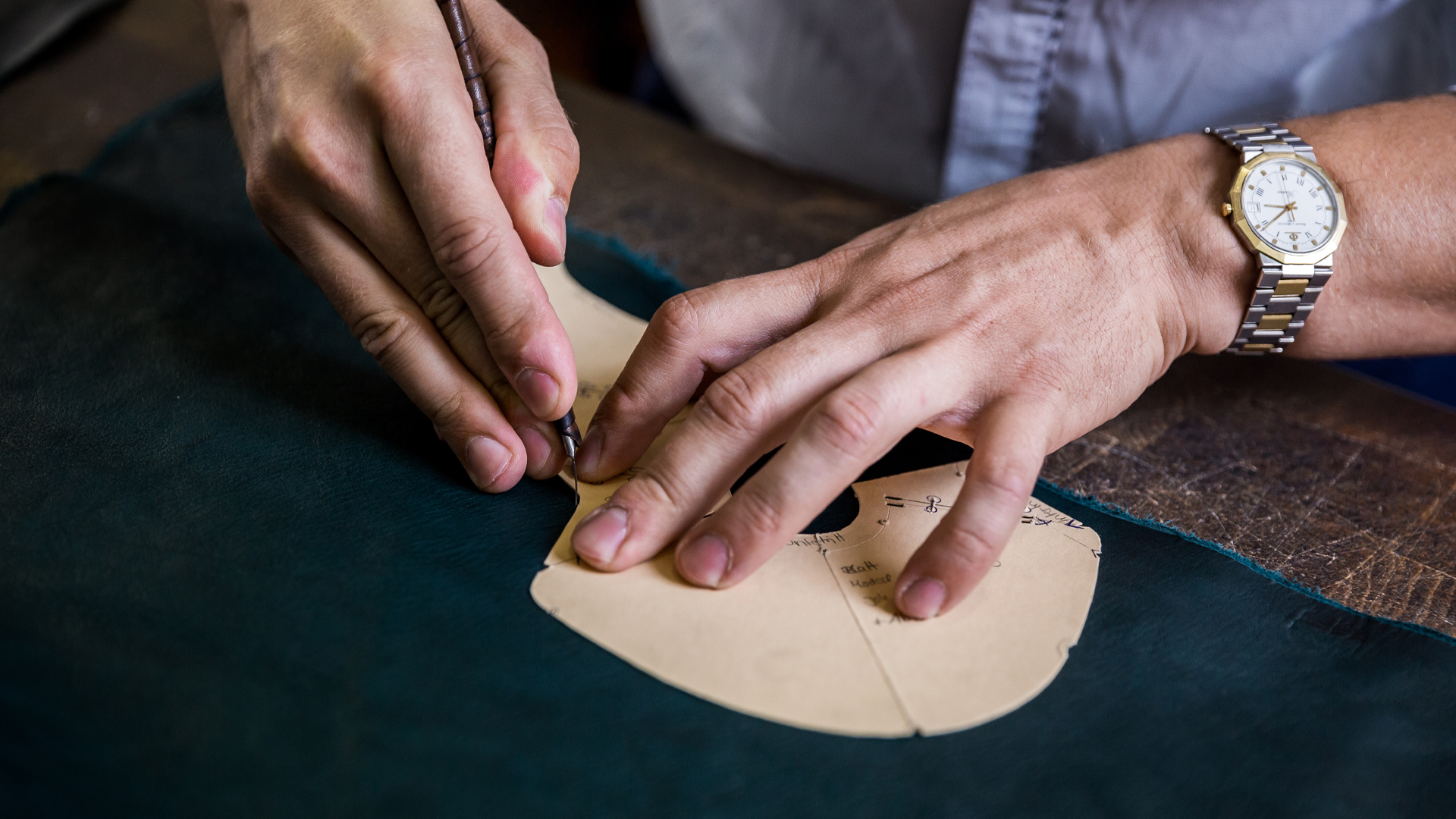 Der Schuhmacher schneidet das Leder für den Schuh zu