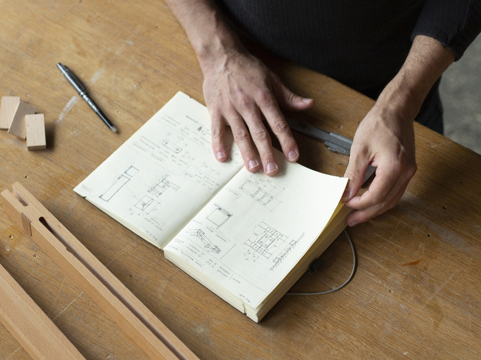 Hände auf Skizzenbuch für Möbel