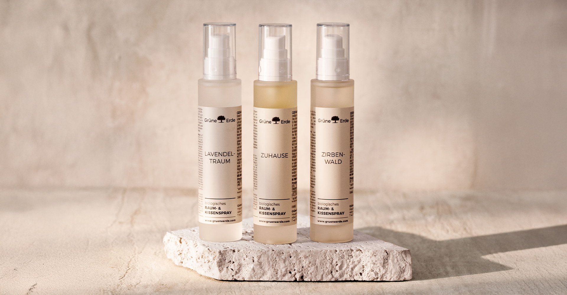 Drei Raumsprays mit ätherischen Ölen auf Naturstein in ruhiger Umgebung