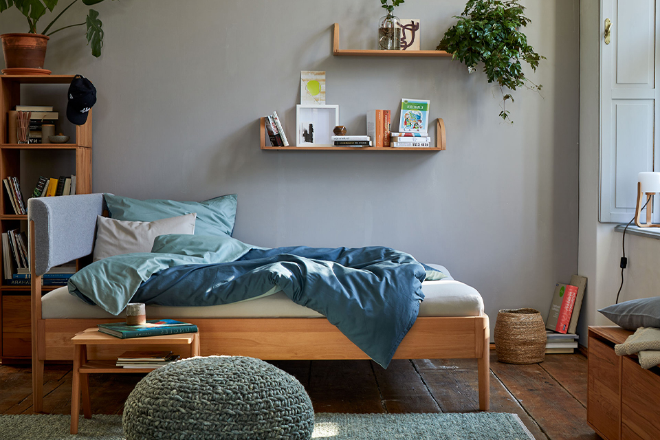 Schlafzimmer mit Holzbett und dekorativen Regalen in gemütlicher moderner Einrichtung