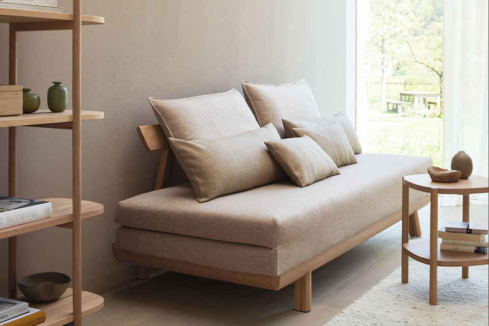 Bettsofa Doppio mit Regal und Beistelltische im Raum