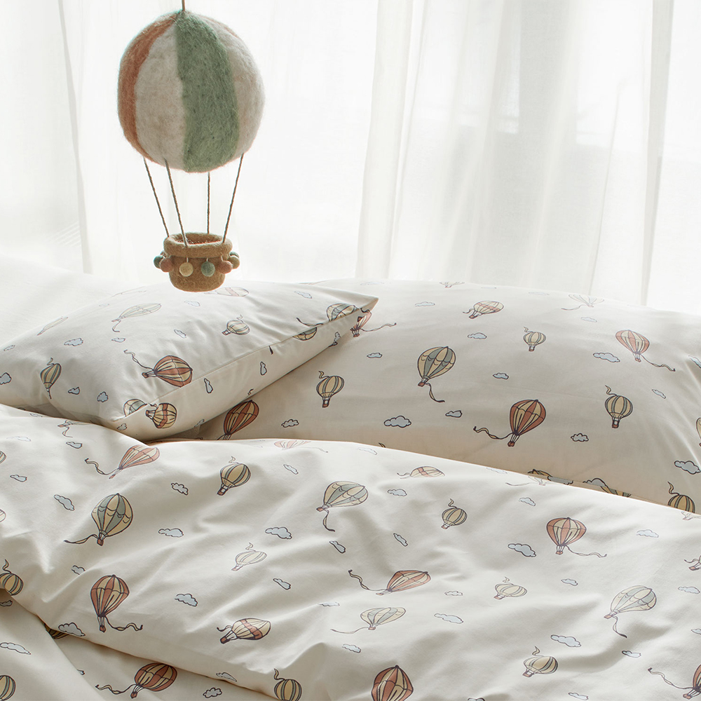 Kinderbettwäsche mit Heißluftballon-Muster auf einem Bett