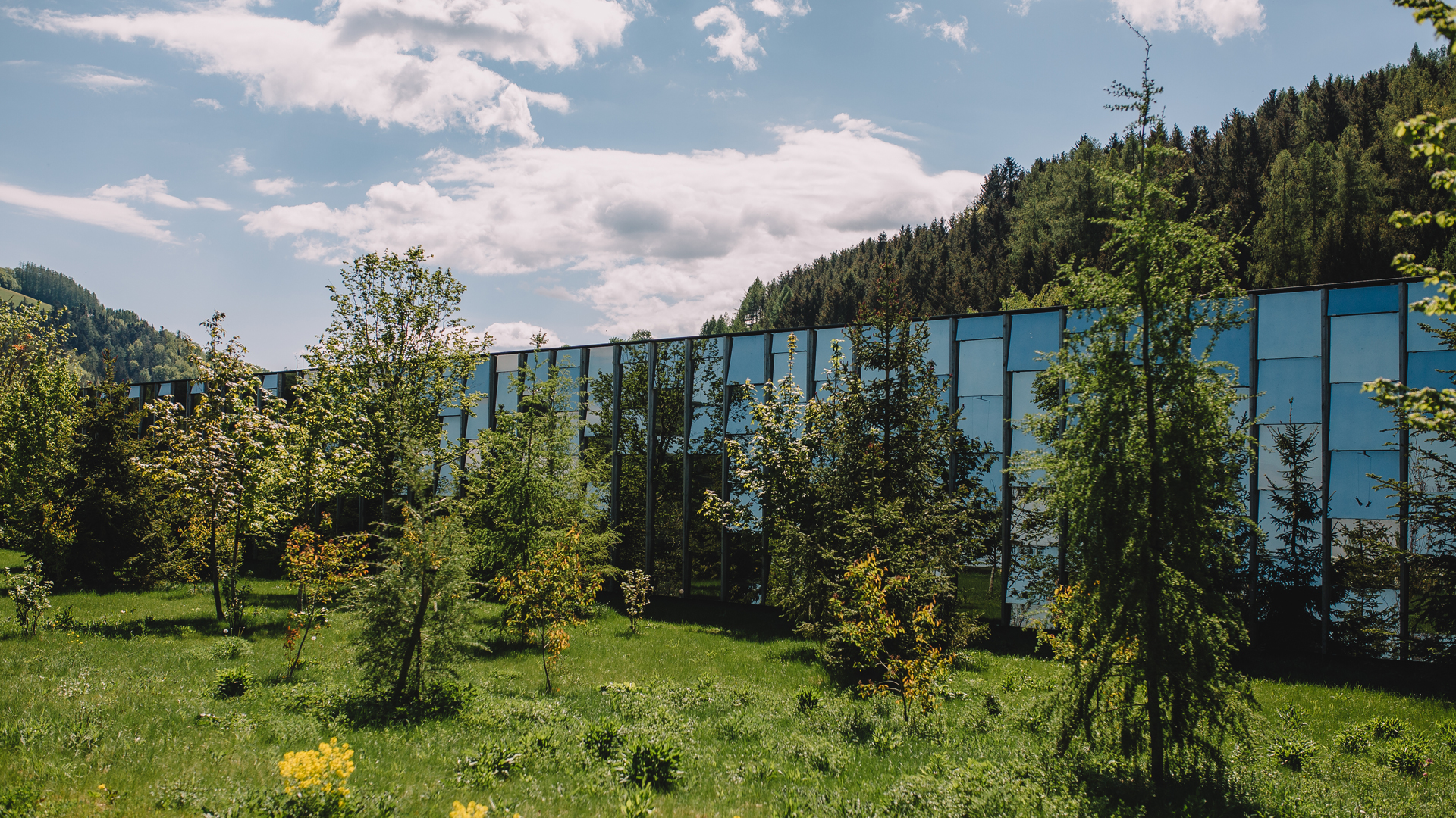 Grüne Erde Welt modernes Glasgebäude in naturnaher Wiesenlandschaft