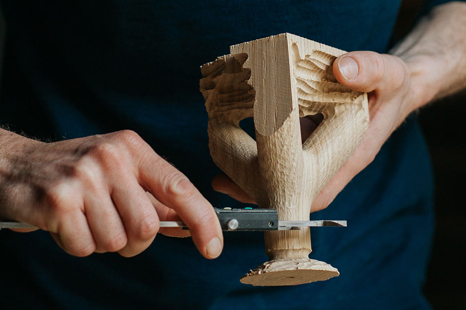 Hände bearbeiten Holzstück mit Werkzeug in Werkstatt