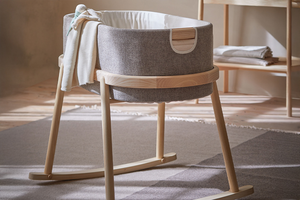 Babywiege Serafin mit Stillkissen und Kuscheldecke im Kinderzimmer