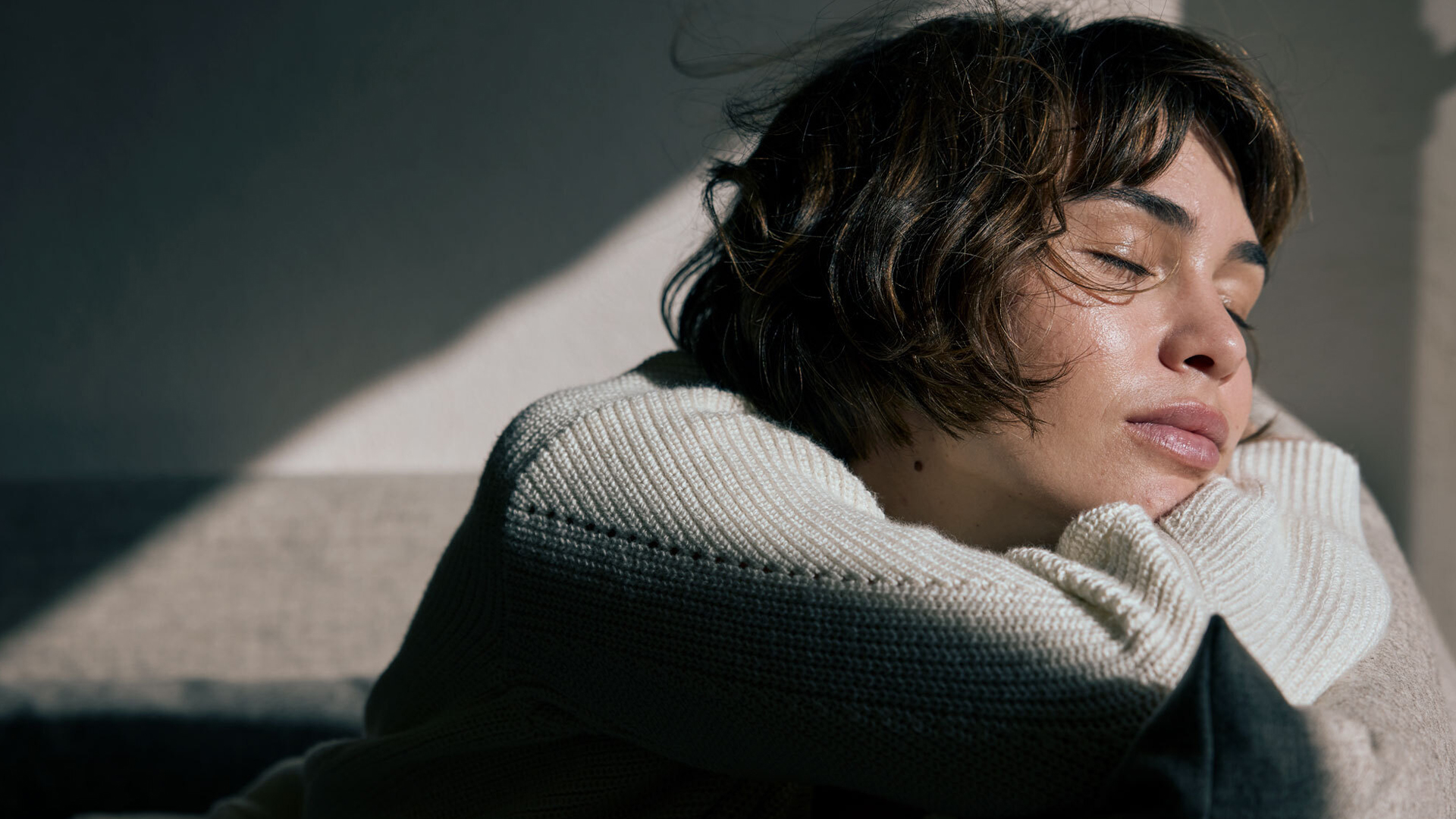 Frau ruht entspannt mit geschlossenen Augen im weichen Licht