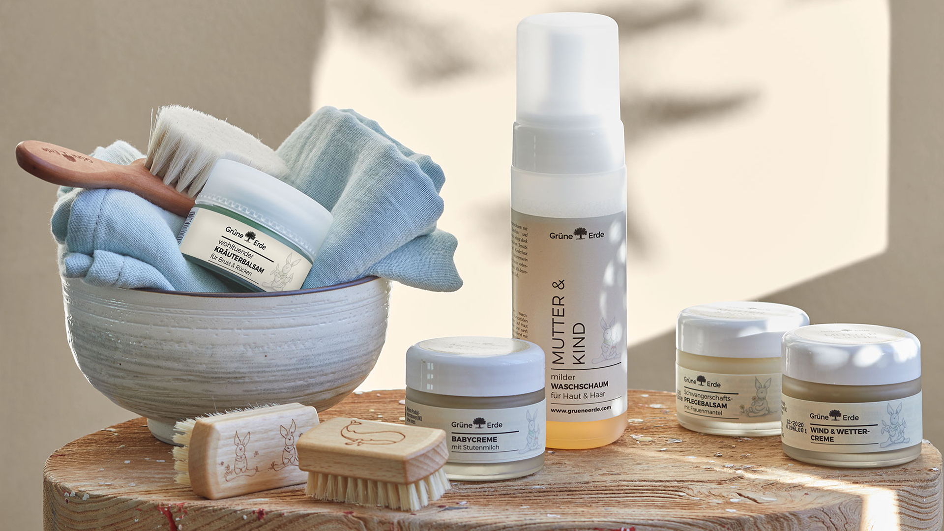 Babypflegeprodukte mit Bürsten auf einem dekorativen Baumstumpf