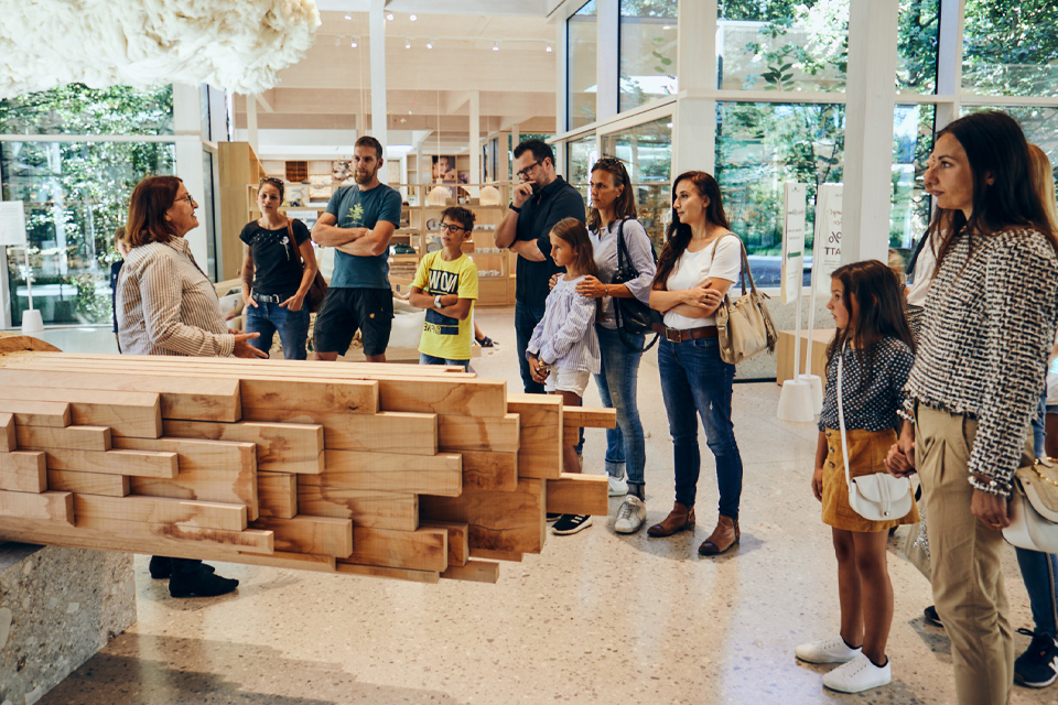Gruppe steht im Ausstellungsraum und folgt einer Führung aufmerksam