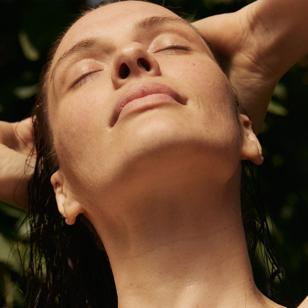 Frau mit geschlossenen Augen genießt entspannenden Moment in der Natur